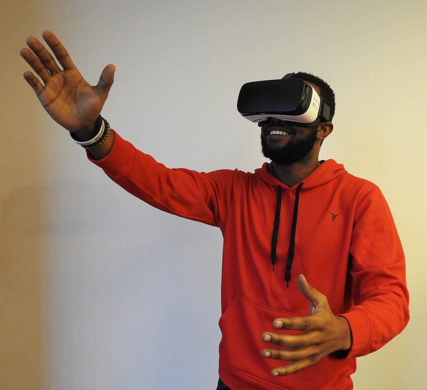 man wearing white VR headset while lifting right hand virtual reality