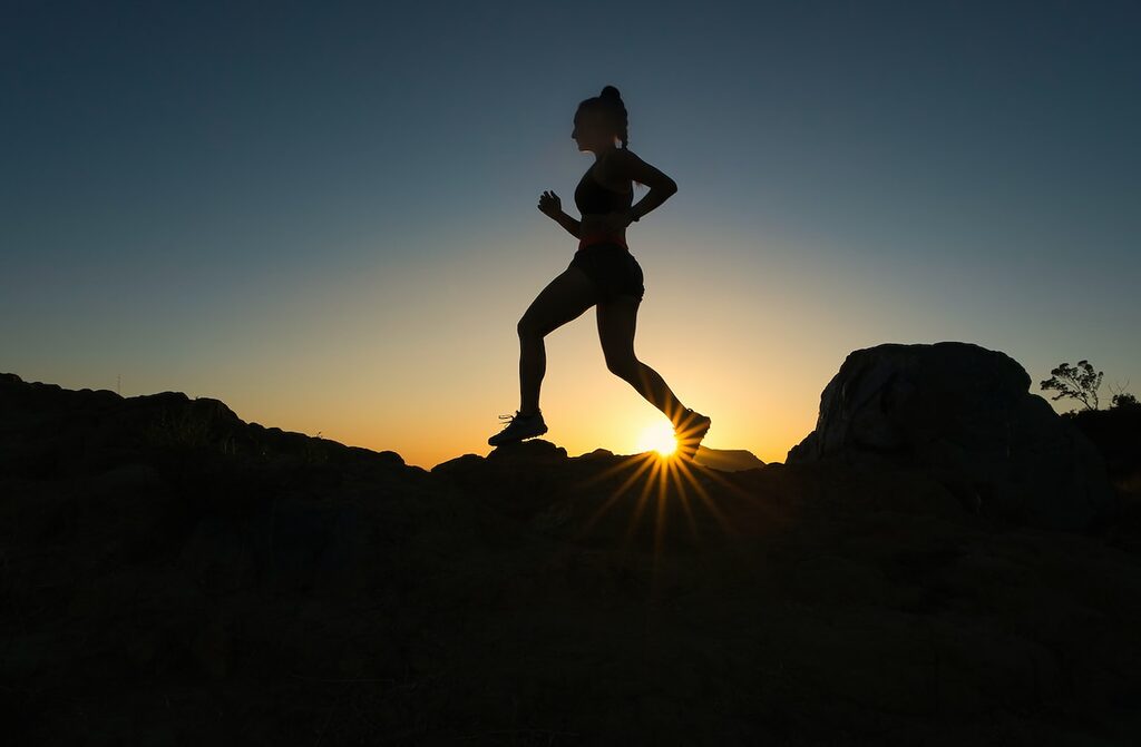 silhouette of woman running at sunset photo sport