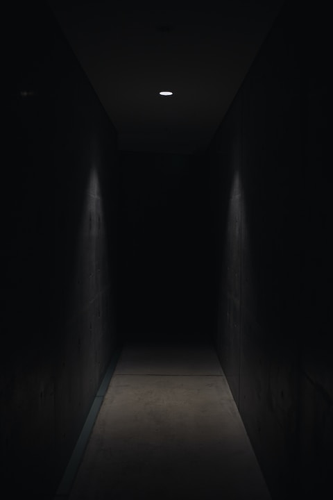 dark pathway lit with small light fixture horror movie